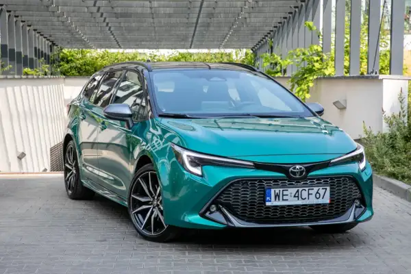 Zielona Toyota Corolla kombi z czarnym dachem, prezentująca swoje dynamiczne linie. Idealna do miasta i na dalsze trasy, jej toyota corolla wymiary zapewniają komfort.
