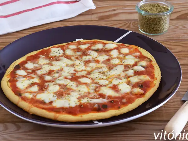 Pizza de garbanzos con queso derretido y salsa de tomate, lista para disfrutar.