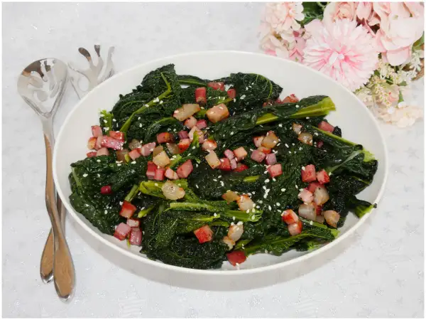 Cavolo nero in padella senza bollire, saltato con cubetti di pancetta croccante e semi di sesamo. Un contorno saporito e veloce.