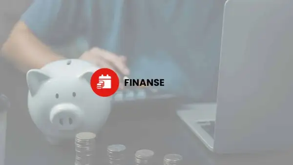Skarbonka, monety i laptop sugerują zarządzanie finansami, w tym potencjalny podatek od darowizny.