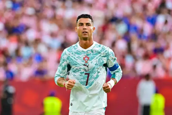 Ronaldo piłkarz w nowej koszulce Portugalii, gotowy do gry. Tłum kibiców na trybunach.
