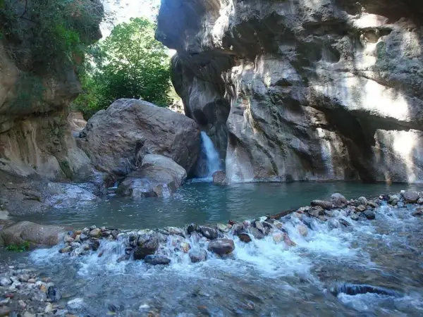 Un rincón idílico en las cascadas de Padules, Almería, donde el agua cristalina fluye entre rocas y vegetación exuberante.