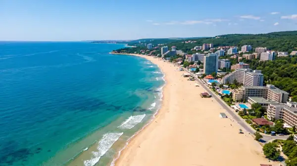Bułgaria, czerwiec: słoneczna pogoda na szerokiej plaży z hotelami i turkusowym morzem. Idealne warunki na wakacje.