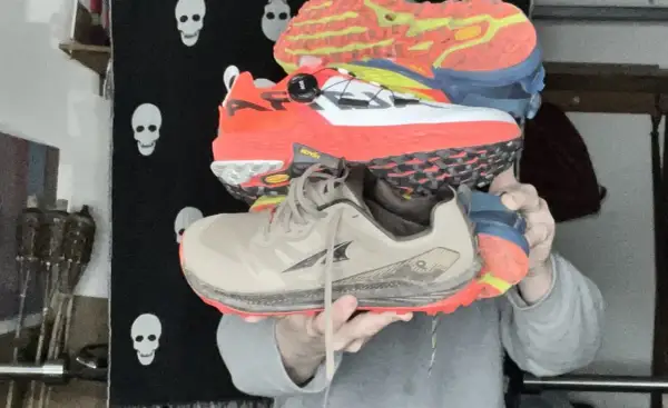 Trois paires de chaussures de trail colorées, empilées. Peut-on courir avec des chaussures de trail sur route ?