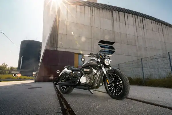 Czarny motocykl typu chopper 125 na tle nowoczesnego budynku.