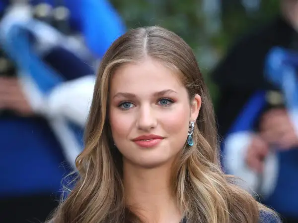 La principessa Leonor, con i suoi occhi azzurri e i capelli biondi, sorride con un elegante orecchino.