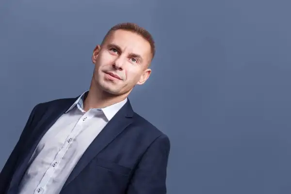 Mężczyzna w garniturze i białej koszuli, patrzący w górę.