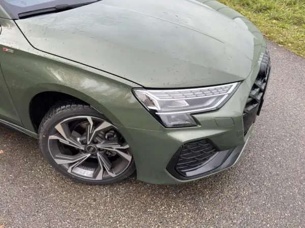 Zielony Audi A3 kombi z felgami S line na mokrej drodze.
