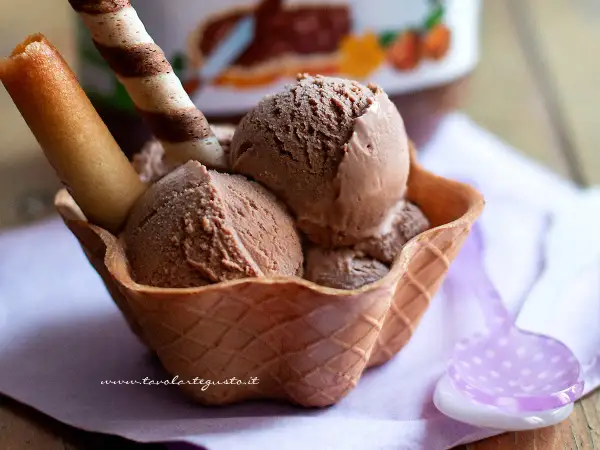 Coppa di gelato alla nutella fatto in casa, con cialda croccante e biscotti.