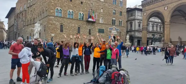 Un gruppo di escursionisti festeggia a Firenze, pronto per le tappe della Via degli Dei.