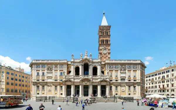 Bazylika Santa Maria Maggiore w Rzymie, z charakterystyczną wieżą zegarową, na tle błękitnego nieba.