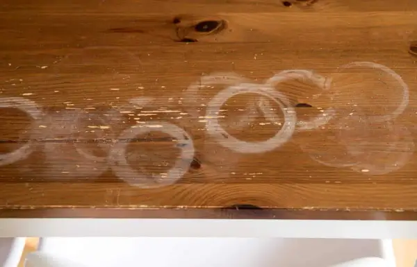 Cercles blancs sur bois : une tache de chaleur laissée par une tasse chaude.