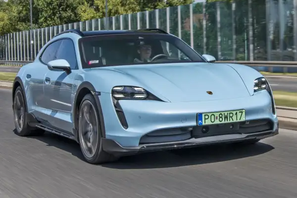 Jasnoniebieski Porsche Taycan Cross Turismo w ruchu. Sprawdź aktualną porsche taycan cena i możliwości tego elektrycznego kombi.