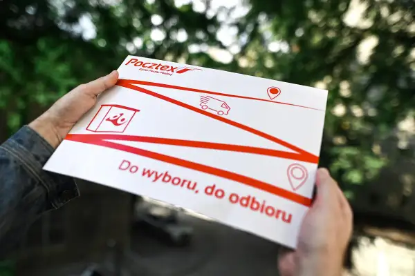 Ręce trzymają białą kopertę Pocztex z czerwonymi liniami i ikonami. Napis "Do wyboru, do odbioru" sugeruje opcje dostawy.