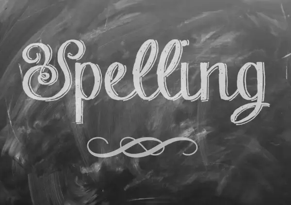 Het woord "Spelling" is met sierlijke letters op een krijtbord geschreven. Een decoratieve krul siert de onderkant.