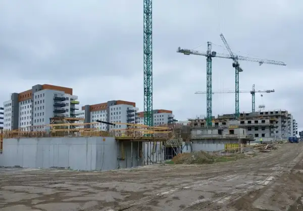 Budowa osiedla mieszkaniowego, gdzieś tu może być odpowiedź, jak dostać mieszkanie z wojska. Dźwigi i budynki w tle.