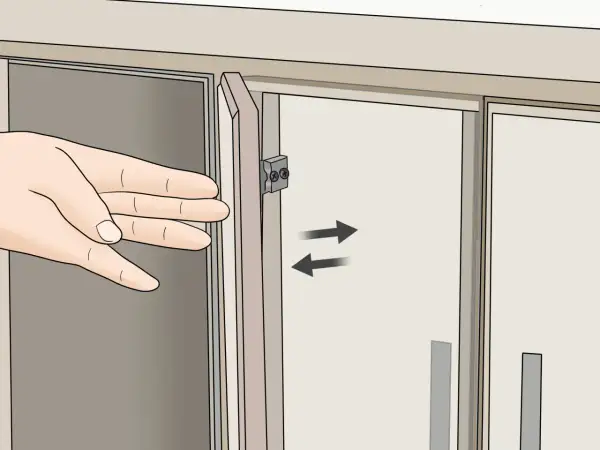 Mano ajustando la puerta de un armario con bisagras.