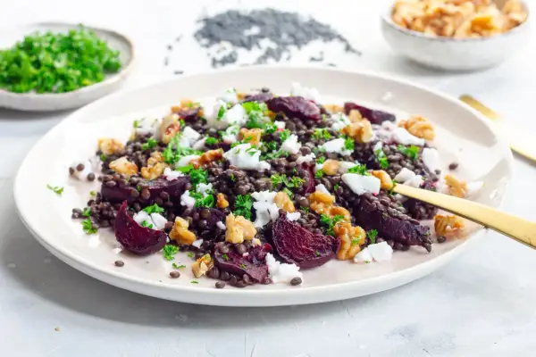 Leckerer Rote Bete-Linsen Salat mit Feta und Walnüssen, garniert mit Petersilie. Ein bunter und gesunder Genuss.