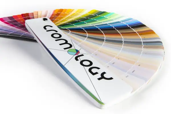 Ventaglio di campioni di vernici, una tabella colori che mostra un arcobaleno di tonalità, dal rosso al blu, con il logo "cromology" in primo piano.