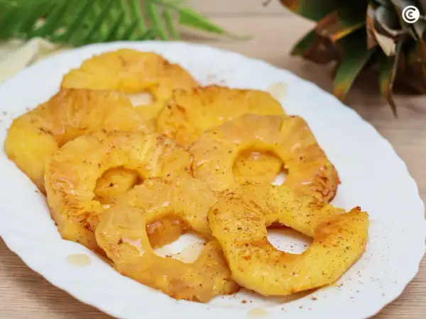 Rodajas de piña a la plancha, doradas y jugosas, espolvoreadas con canela. Un postre tropical irresistible.