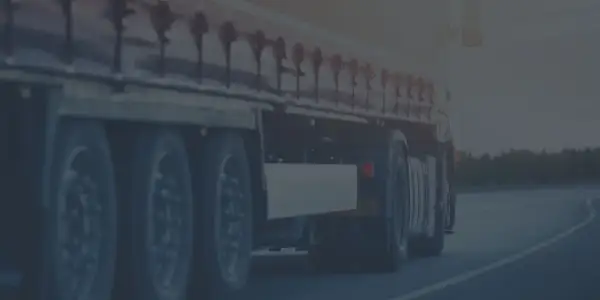 Ciężarówka w ruchu drogowym, przygotowana do testów na przewóz rzeczy. Widok na koła i naczepę.