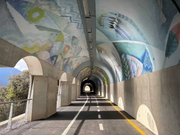 Ciclabile Riva del Garda: un tunnel artistico con affreschi colorati sul soffitto e un percorso ben segnalato.
