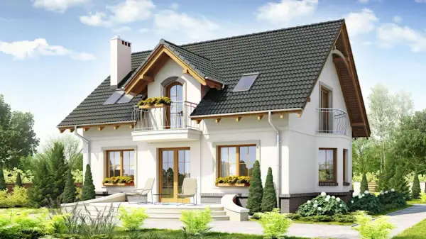 Nowy dom z pięknymi oknami i balkonem. Dbałość o detale, jak obróbka okna, podkreśla jego urok.