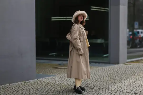 Eleganckie loafersy damskie dopełniają stylizację z beżowym płaszczem i futrzaną czapką.