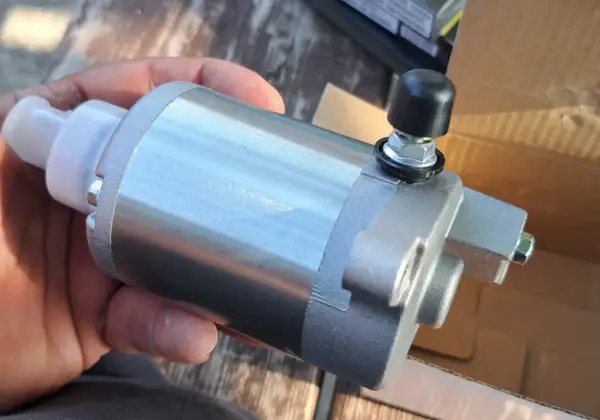 Nowy rozrusznik elektryczny zamiast szarpaka, trzymany w dłoni.