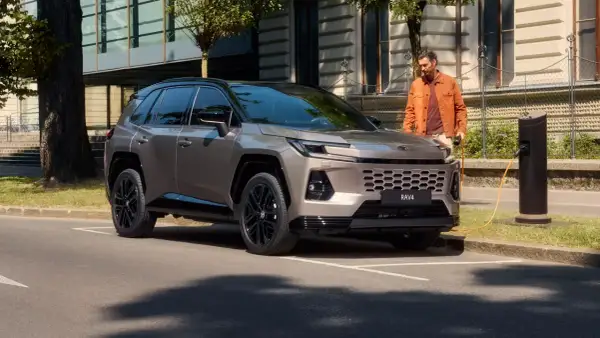 Nowy Toyota RAV4 2025 cena: stylowy SUV ładowany przy miejskiej stacji.