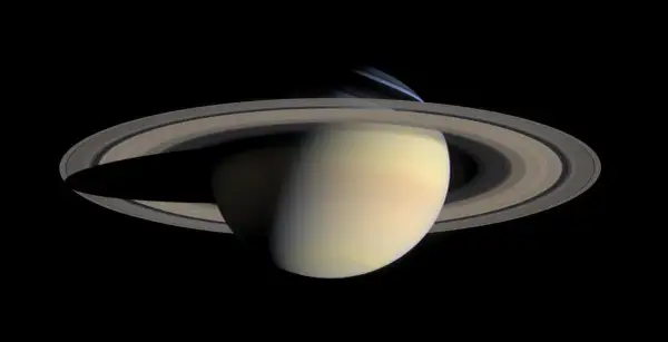 Saturnus med sina ringar, där nattsidan visar den kalla saturnus temperatur.