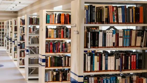 Rzędy regałów z książkami w bibliotece. Wśród nich można znaleźć pozycje dotyczące historii, w tym język chorwacki.
