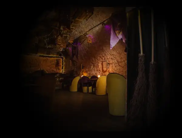 Magiczne wnętrze, jak z muzeum Harry Potter w Krakowie. Miękkie fotele, kamienne ściany i miotły czekają na czarodziejów.