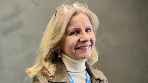 Helene Barnekow ler mot kameran, med glasögon på huvudet och en beige polotröja under en brun jacka.