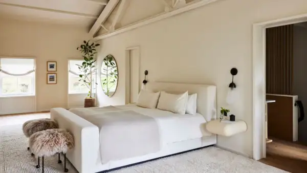 Serene bedroom with a large bed, fluffy stools, and a plant, creating positive energy placement feng shui bedroom vibes.