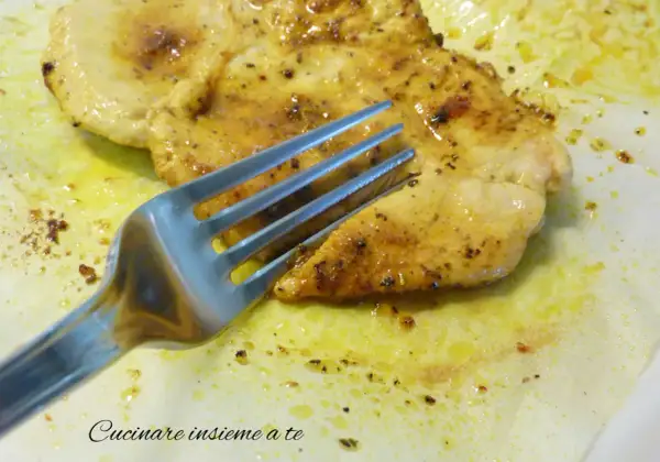 Un succulento petto di pollo in padella morbido, dorato e speziato, pronto per essere gustato con una forchetta.