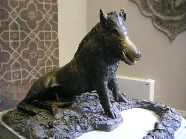 Sculpture d'un sanglier, inspirée par l'art de Florence, posé sur un socle rocheux.