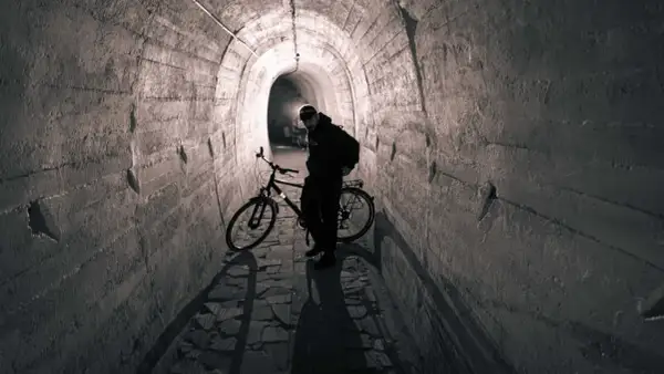 Mężczyzna z rowerem w tunelu. To może być początek jego przygody na podziemnej trasie rowerowej.