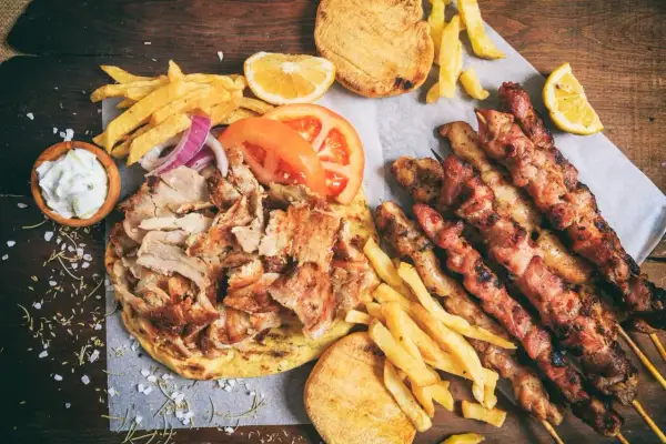 Zapiekanka z kurczakiem gyros, frytkami, pitą, sosami i szaszłykami z kurczaka.
