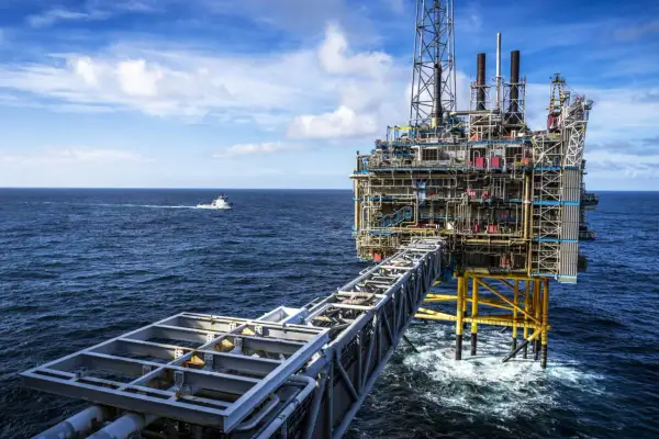 Ölplattform im Meer, die den Reichtum des norwegischen Staatsfonds repräsentiert. Ein Versorgungsschiff fährt vorbei.