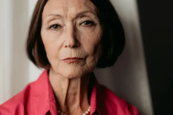 Portret starszej kobiety w różowej bluzce, z naszyjnikiem z pereł. Ewa Woydyłło-Osiatyńska, pierwsza żona, wspomina.
