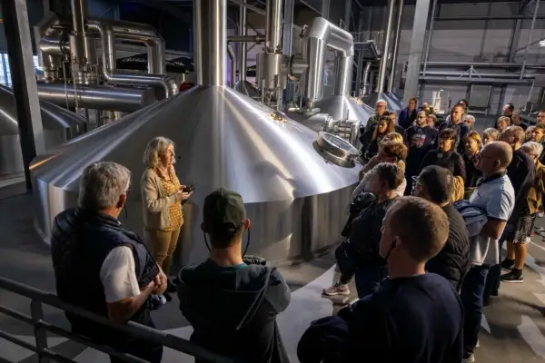 Visite Goudale : un groupe découvre les cuves de brassage. Une guide explique le processus de fabrication de la bière.