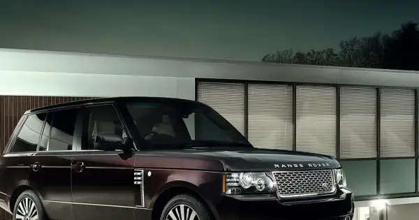 Elegancki Range Rover Autobiography w ciemnym kolorze lśni przed nowoczesnym budynkiem z przeszklonymi oknami.