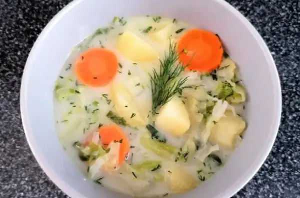 Aksamitna zupa z białej kapusty z ziemniakami i marchewką, ozdobiona koperkiem. Pyszne, domowe danie.