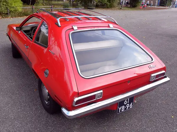Czerwony Ford Pinto Runabout z bagażnikiem dachowym, gotowy na przygodę.