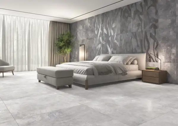 Dormitorio moderno con suelo de porcelánico rectificado, cama confortable y pared decorativa con diseño abstracto.