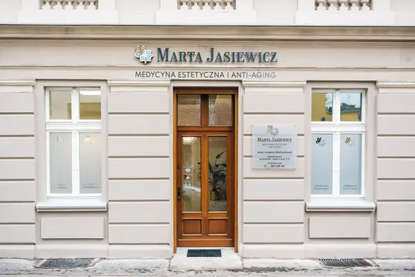 Elegancka fasada kliniki medycyny estetycznej Marta Jasiewicz z drewnianymi drzwiami i oknami.