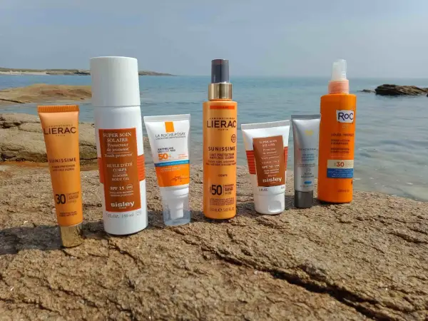 Des crèmes solaires Lierac, Sisley, La Roche-Posay, Skinceuticals et Roc sur des rochers. Elles servent à protéger la peau des rayons UV et à prévenir le vieillissement cutané.