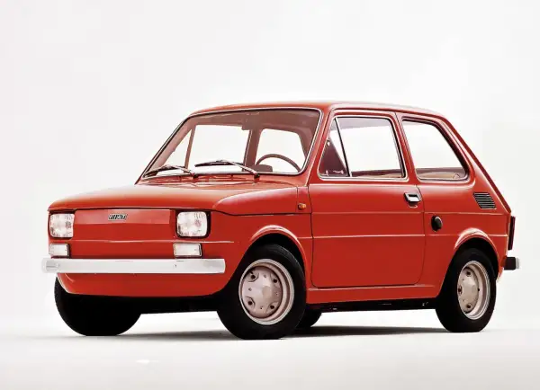 Czerwony fiat 126p, kultowy "maluch", prezentowany na białym tle.