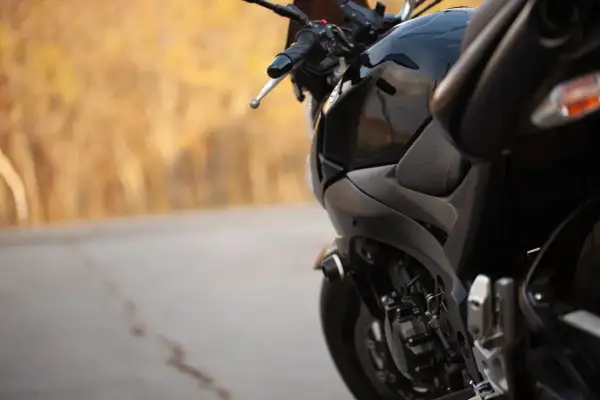 Czarny motocykl na tle jesiennego krajobrazu. Zastanawiasz się, jaki przebieg dla motocykla jest duży? Ten wygląda na gotowy na wiele przygód.